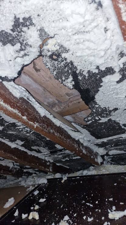 Foam peeled from the lining reveals gaps and a deteriorated roof covering underneath.
